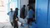 নৌকাডুবিতে নিহত এক অভিবাসন প্রত্যাশীর মরদেহ বহন করে নিয়ে যাচ্ছেন কয়েক ব্যক্তি; লিবিয়া, ২৫ এপ্রিল ২০২৩। 