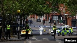 FILE - Police forensics officers work at a site cordoned with police tape, following a major incident in Nottingham city centre, Nottingham, Britain, June 13, 2023. 