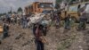 Un jeune garçon porte quelques-uns de ses biens alors que les gens fuient le territoire de Masisi suite aux affrontements entre les rebelles du M23 et les forces gouvernementales, sur une route près de Sake le 7 février 2024. (Photo par Aubin Mukoni / AFP)