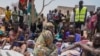 FILE - South Sudanese who fled from Sudan sit outside a nutrition clinic at a transit center in Renk, South Sudan, May 16, 2023.