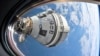This photo provided by NASA shows Boeing's Starliner spacecraft docked to the Harmony module's forward port on July 3, 2024, seen from a window on the SpaceX Dragon Endeavour spacecraft docked to the adjacent port. 