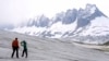 Team members of ETH (Swiss Federal Institute of Technology) glaciologist and head of the Swiss measurement network 'Glamos', Matthias Huss, drill holes into the Rhone Glacier to take measurements near Goms, Switzerland, June 16, 2023.