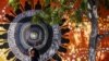 ILUSTRASI - Seorang perempuan melindungi wajahnya dari sinar matahari saat dia berjalan melewati dinding yang dihiasi mural Penduduk Asli Australia di ibu kota Darwin, 29 Agustus 2023.(DAVID GREY / AFP)