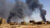 FILE: A man walks while smoke rises above buildings after aerial bombardment, during clashes between the paramilitary Rapid Support Forces and the army in Khartoum North, Sudan, May 1, 2023. 