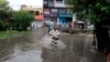 A motorcyclist drives through a road flooded by heavy rain in Peshawar, Pakistan, July 30, 2024. 