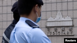 FILE - Police stand guard outside the West Kowloon Magistrates' courts in Hong Kong, China, Nov. 25, 2022. Lawmakers on Wednesday voted to restrict foreign lawyers from handling national security cases.