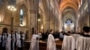 FILE - Members of the clergy process in for the Choral Evensong service at Southwark Cathedral in London, March 15, 2020.