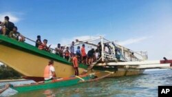 Para penumpang kapal feri yang diselamatkan oleh penjaga pantai Filipina, tiba di pelabuhan di Polillo, di provinsi Quezon, Filipina timur laut, 3 Agustus 2023. (Penjaga Pantai Filipina via AP)