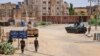 Sudanese Army soldiers walk near armored vehicles positioned on a street in southern Khartoum, May 6, 2023, amid ongoing fighting between the Army and the paramilitary Rapid Support Forces.
