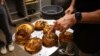 Andrew Martinez, pemilik toko bagel Bo's Bagels, menunjukkan bagels yang baru dipanggang di tokonya di Kota New York, 12 Juli 2023. (Foto: Yuki Iwamura/AFP)