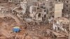 FILE - Rescuers and relatives of victims set up tents in front of collapsed buildings in Derna, Libya, Sept. 18, 2023. 