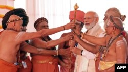 ইন্ডিয়ান প্রেস ইনফরমেশন ব্যুরো (পিআইবি) থেকে প্রকাশিত এই ছবিতে নয়াদিল্লিতে নতুন সংসদ ভবনের উদ্বোধনের সময় পুরোহিতদের সাথে ভারতের প্রধানমন্ত্রী মোদীকে দেখা যায়। (২০২৩ সালের ২৮ মে)