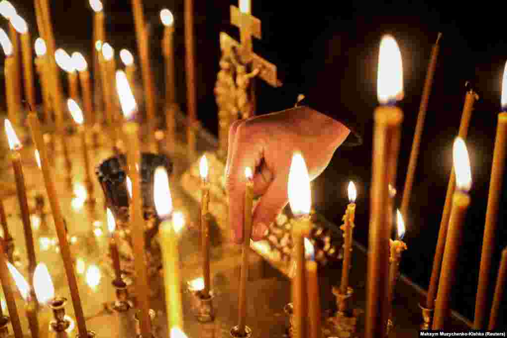 Una persona coloca una vela durante un servicio de Pascua ortodoxa en la Iglesia de Todos los Santos de Chernihiv, en medio del ataque de Rusia a Ucrania, en Chernihiv, Ucrania, el 4 de mayo de 2024. REUTERS/Maksym Muzychenko-Kishka