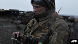 Архівне фото, березень 2023 : Український військовий з мобільним телефоном в Донецькій області.