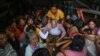 People evacuate on a truck in Sittwe in Myanmar's Rakhine state on May 13, 2023, ahead of the landfall of Cyclone Mocha.
