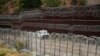 FILE - A vehicle drives along the US side of the US-Mexico border wall in Nogales, Ariz., June 25, 2024.
