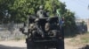 Un convoi militaire des Forces de défense nationale sud-africaines (SANDF) circule sur un chemin de terre dans le district de Maringanha à Pemba, le 5 août 2021.