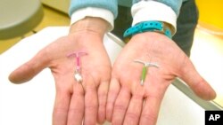 FILE - Dr. Susan Gorman displays the Skyla IUD, left, and the Mirena IUD, at High Lakes Gynecology in Redmond, Ore., Jan. 14, 2015. 