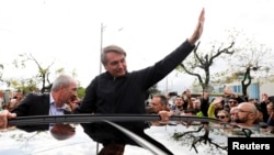 Brazil's former President Jair Bolsonaro waves as he greets supporters at Salgado Filho International Airport, on the day the Electoral Justice begins the trial to determine his political rights, as he arrives in Porto Alegre, Rio Grande do Sul, Brazil, June 22, 2023.