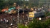 Onlookers are seen gathered as crews work at the site of a deadly train derailment in Balasore district, in the eastern Indian state of Odisha, June 4, 2023.