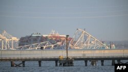 Des images de vidéosurveillance montrent ce qui semble être un porte-conteneurs heurtant un pilier du pont, le faisant tomber avec une grande partie de sa structure métallique.