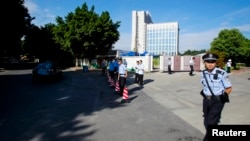 FILE - Policemen guard in front of an entrance to a court where the trial of Guo Feixiong's was taking place, in Guangzhou, Sept. 12, 2014. Guo was sentenced to 8 years in prison on May 11, 2023, with diplomats from several countries saying they were barred from the trial. 