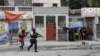 FILE - People huddle in a corner as police patrol the streets after gang members tried to attack a police station, in Port-au-Prince, Haiti, April 25, 2023. An escalation of armed violence has worsened food insecurity and a cholera outbreak in Haiti, according to UNICEF.