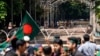 Military and paramilitary personnel stand guard as protesters block the road in front of the former residence of Sheikh Mujibur Rahman, father of the ousted Prime Minister Sheikh Hasina, on his death anniversary in Dhaka, Bangladesh, Aug. 15, 2024.