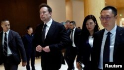 Tesla Chief Executive Officer Elon Musk, center, walks next to Tesla's Senior Vice President Tom Zhu and Vice President Grace Tao as he leaves a hotel in Beijing, May 31, 2023.