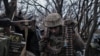 Украинский солдат готовит боеприпасы для обстрела российских передовых позиций близ Бахмута, в Донецкой области Украины, 11 марта 2023 года.