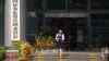 FILE - A woman walks out of the China Securities Regulatory Commission on Financial Street in Beijing, July 9, 2015.