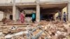 People inspect the rubble at a house that was hit by an artillery shell in the Azhari district in the south of Khartoum on June 6, 2023. 