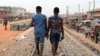 FILE - Chris Agiriga (23), salah satu pria Nigeria yang ditangkap atas tuduhan menunjukkan kemesraan di depan umum dengan sesama jenis, berjalan dengan seorang temannya di jalan Mushin di Lagos, Nigeria, 14 Februari 2020. (REUTERS/Temilade Adelaja)