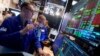 Specialist Patrick King, left, works at his post on the floor of the New York Stock Exchange, Aug. 6, 2024.