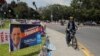 A person rides a bicycle next to posters of candidates for the general elections, in Guatemala City, Guatemala, March 27, 2023.
