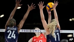 Li Yingying of China spikes the ball as Chiaka Ogbogu and Andrea Drews of the United States try to block her during the group A women's volleyball match between the United States and China at the 2024 Summer Olympics, July 29, 2024, in Paris.