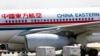 FILE - A carter drives past a China Eastern airliner parked at the Beijing International Airport in Beijing on Aug. 29, 2007.