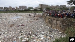 People watch from the edge of a quarry where human remains were found in Mukuru Kwa Njenga area, in Nairobi, Kenya, July 13, 2024.