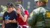 FILE - A woman cries as she leaves the Uvalde Civic Center after a school shooting at Robb Elementary School, May 24, 2022, in Uvalde, Texas.