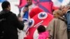 Spectators pose with the Olympic Phryge, France's Olympic mascot, ahead of rowing competitions at the 2024 Summer Olympics, in Vaires-sur-Marne, France, July 27, 2024.