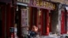 FILE - A Chinese man sits outside convenience store in Beijing, July, 26, 2024. 