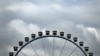 FILE - Clouds hang over a Ferris wheel during the Oktoberfest beer festival in Munich, southern Germany, Sept. 17, 2022. A Ferris wheel caught fire Saturday night at a music festival near Leipzig in eastern Germany, injuring at least 23 people, 