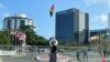 Una mujer camina por la plaza central de Georgetown con el Pegasus Suites Corporate Center un edificio de 12 pisos que es el más alto del país, se ve al fondo en Georgetown, Guyana, el 17 de febrero de 2022.
