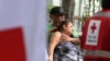 A couple waits for the body of their relative, one of the 46 women killed during a fire following a brawl between inmates of the Women's Social Adaptation Center (CEFAS) prison in Tegucigalpa, Honduras, on June 21, 2023. 