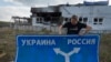 Ukrainian historian Yuri Savchuk, head of the Kyiv-based Ukrainian WWII history museum, carries a road sign in Sudzha, in Russia's Kursk region, Aug. 16, 2024. The image was approved by the Ukrainian Defense Ministry before publication. 