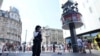 A Police officer stands at the scene in Leicester Square, as a man was arrested with the accusation of stabbing an 11-year-old girl and 34-year-old woman, in London, Aug. 12, 2024.