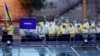 Ukraine's athletes wave Ukrainian flags aboard a boat as it makes its way along the Seine river in Paris, France, during the opening ceremony for the 2024 Summer Olympics, July 26, 2024. 
