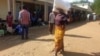 A woman carries maize meal from a U.N. World Food Program distribution center in Neno district, southern Malawi, March 24, 2024. Drought left millions facing hunger in southern Africa; Malawi declared a state of disaster earlier this year.