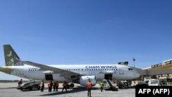 Sejumlah karyawan menurunkan koper-koper dari bagasi pesawat yang baru tiba di Bandara Aleppo, Suriah, 11 Maret 2023 sehari setelah dibuka kembali menyusul serangan Israel pada 7 Maret. (Foto: AFP)