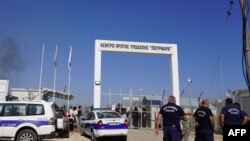 FILE - Pasukan keamanan Siprus berjaga di pintu masuk kamp Pournara, pusat penerimaan utama migran di Siprus, setelah dilaporkan adanya kerusuhan di fasilitas di Kokkinotrimithia, tepi ibu kota Nicosia tersebut, 28 Oktober 2022 . (Etienne TORBEY / AFP)